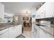 Open concept kitchen with white cabinets, granite counters and stainless steel appliances at 5122 Northridge Rd # 107, Sarasota, FL 34238