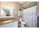 Bathroom with granite vanity, white cabinets and floral shower curtain at 5122 Northridge Rd # 107, Sarasota, FL 34238