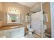 Bathroom with granite vanity, white cabinets and floral shower curtain at 5122 Northridge Rd # 107, Sarasota, FL 34238