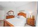 Main bedroom with wood furniture and a view into the bathroom at 5122 Northridge Rd # 107, Sarasota, FL 34238