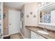 Bathroom boasts granite countertop, white cabinets, and a floral shower curtain at 5122 Northridge Rd # 107, Sarasota, FL 34238