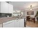 Modern kitchen with white cabinets, granite countertops, and a view of the dining area at 5122 Northridge Rd # 107, Sarasota, FL 34238