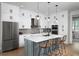 Modern kitchen with white cabinets, island, and stainless steel appliances at 9957 Key Haven Rd, Seminole, FL 33777