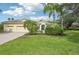 House exterior showcasing a lush green lawn and palm trees at 7602 Partridge Street Cir, Bradenton, FL 34202