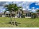 Spacious backyard with lush lawn, palm trees, and a screened patio at 7407 64Th E St, Palmetto, FL 34221