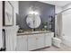 Stylish bathroom with patterned wallpaper and a round mirror at 13212 Deep Blue Pl, Lakewood Ranch, FL 34211