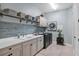 Laundry room with white cabinets, subway tile, and built-in shelving at 13212 Deep Blue Pl, Lakewood Ranch, FL 34211