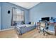 Bright bedroom with light blue walls, full bed, and workspace at 6122 44Th E Ct, Bradenton, FL 34203