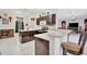 L-shaped kitchen with dark wood cabinets, an island with seating, and a view into the dining area at 6122 44Th E Ct, Bradenton, FL 34203