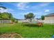 Large grassy backyard with trampoline, privacy fence, and mature trees at 6122 44Th E Ct, Bradenton, FL 34203