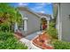 Home's entrance with red door, fountain, and lush landscaping at 6122 44Th E Ct, Bradenton, FL 34203