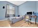 Bright bedroom with light blue walls, full bed, and workspace at 6122 44Th E Ct, Bradenton, FL 34203
