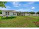 Backyard view showing grassy area, screened patio, and home exterior at 6122 44Th E Ct, Bradenton, FL 34203