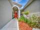 Inviting entryway with red door and landscaping at 6122 44Th E Ct, Bradenton, FL 34203