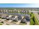 An aerial view of a neighborhood highlighting homes surrounding a picturesque pond with a sprawling green landscape beyond at 9478 Tequila Sunrise Dr, Sarasota, FL 34241