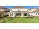 The backyard includes a covered patio, manicured lawn, and view of the pond at 9478 Tequila Sunrise Dr, Sarasota, FL 34241