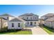 Two-story home showcases a white exterior, gray accents, well-manicured lawn, and an attached two-car garage at 9478 Tequila Sunrise Dr, Sarasota, FL 34241