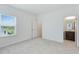 Bright bedroom featuring grey carpet, window, and ensuite bathroom at 9478 Tequila Sunrise Dr, Sarasota, FL 34241
