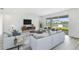 Living room with wood-look floors, ample natural light, and access to a patio overlooking a lake at 9478 Tequila Sunrise Dr, Sarasota, FL 34241