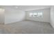 Spacious loft area with grey carpeting and multiple windows at 9478 Tequila Sunrise Dr, Sarasota, FL 34241