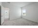 Spacious bedroom with grey carpet, window, and access to another room at 9478 Tequila Sunrise Dr, Sarasota, FL 34241
