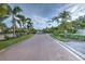 Brick-paved entrance to a community with lush landscaping and palm trees at 7823 33Rd E St # 20, Sarasota, FL 34243
