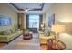 Spacious living room with two green sofas, coffee table, and large window at 7823 33Rd E St # 20, Sarasota, FL 34243