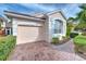 House exterior showcasing a tan color scheme, and brick paver driveway at 7823 33Rd E St # 20, Sarasota, FL 34243