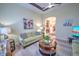 Open living room with green sofa, coffee table, and views to dining area and hallway at 7823 33Rd E St # 20, Sarasota, FL 34243
