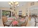 Spacious dining area with a glass-top table and chandelier, overlooking the Gathering room at 7623 Birds Eye Ter, Bradenton, FL 34203