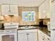 White kitchen with appliances and colorful pendant lighting at 1806 Brook Field Ter, Sarasota, FL 34234