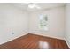 Simple bedroom with wood-look flooring and a window with shutters at 8124 Glenbrooke Pl, Sarasota, FL 34243