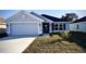 Modern two-car garage home with gray exterior and landscaped lawn at 2620 Averland Loop, North Port, FL 34287