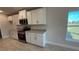 Kitchen boasts white cabinets, granite countertops, and stainless steel appliances at 2620 Averland Loop, North Port, FL 34287