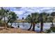 Scenic waterfront view with palm trees and blue skies in a tranquil setting at 2708 Starlite Ln, Port Charlotte, FL 33952