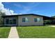 Tan house with black roof, landscaping, and walkway at 2708 Starlite Ln, Port Charlotte, FL 33952