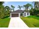 Modern single-story house with a two car garage and well-maintained lawn at 14390 Maddock Ave, Port Charlotte, FL 33953