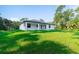Single-story home with covered patio, dark roof and lush green lawn at 14390 Maddock Ave, Port Charlotte, FL 33953