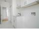 White laundry room with cabinets and marble floor at 14390 Maddock Ave, Port Charlotte, FL 33953