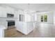 Modern white kitchen with stainless steel appliances and island at 14390 Maddock Ave, Port Charlotte, FL 33953
