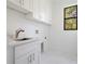 Bright laundry room with sink and white cabinets at 14390 Maddock Ave, Port Charlotte, FL 33953