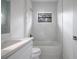 Updated bathroom featuring a white vanity, marble wall tile, and a bathtub at 14390 Maddock Ave, Port Charlotte, FL 33953