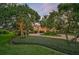 Stunning home with manicured landscaping and palm trees at dusk at 909 Macewen Dr, Osprey, FL 34229
