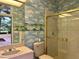 Bathroom with shower, toilet, sink, and cloud wallpaper at 909 Macewen Dr, Osprey, FL 34229