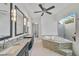 Luxurious bathroom with dual vanities, a soaking tub, and a courtyard view at 909 Macewen Dr, Osprey, FL 34229