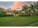 Landscaped backyard with lush lawn and palm trees at 909 Macewen Dr, Osprey, FL 34229