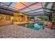 Resort-style pool with covered patio, brick pavers, and large urns at sunset at 909 Macewen Dr, Osprey, FL 34229
