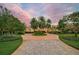 Luxury home with circular driveway, lush landscaping, and palm trees at 909 Macewen Dr, Osprey, FL 34229