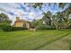 House with a large green lawn, palm trees and hedges at 909 Macewen Dr, Osprey, FL 34229
