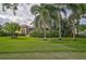 House surrounded by palm trees and a lush lawn at 909 Macewen Dr, Osprey, FL 34229